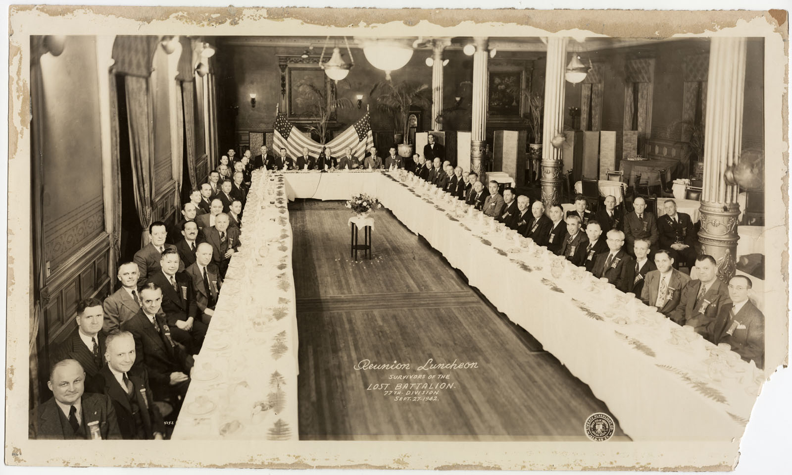 Sephia photograph of a very large group of men seated at long banquet tables
